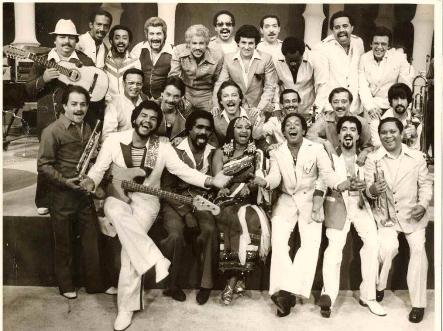 Singers and musicians from Fania Records including Celia Cruz (bottom, center), Ruben Blades (directly above Celia Cruz) and label co-originator, Johnny Pacheco (top row, fifth from left).