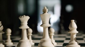 Chess pieces sit on a board. (Mel Evans/AP)
