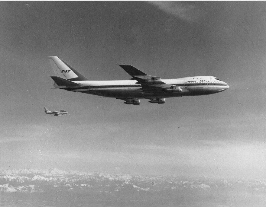 A Boeing model 747, the largest commercial jetliner in the world, flies over the Puget Sound area of western Washington state in October 1969. The 747 jet is accompanied by a Sabre V chase plane, background, to observe certain flight tests. (AP Photo)