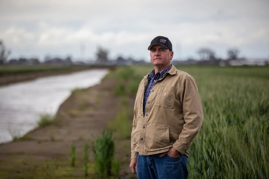 Stephen Mancebo stands near a canal by his farmland in Tulare County on March 23, 2023.