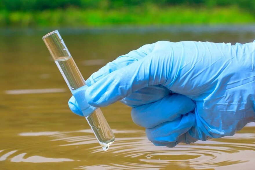 superfund toxic site testing with a test tube held by a gloved hand 