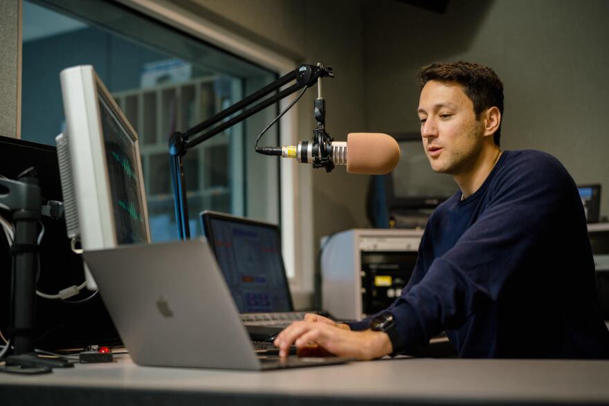 Photo of Jon Reed recording audio in a studio.