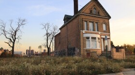 This Oct. 24, 2012 file photo shows a graffiti-marked abandoned home north of downtown Detroit, in background. Thousands of Detroit streetlights are dark, many more residents have fled. Donors are replacing ambulances that limped around for 200,000 miles. Detroit's bankruptcy case is going to trial, Wednesday, Oct. 22, 2013, and the result will determine whether the city can reshape itself in the largest public bankruptcy filing in U.S. history. (AP Photo/Carlos Osorio, File)