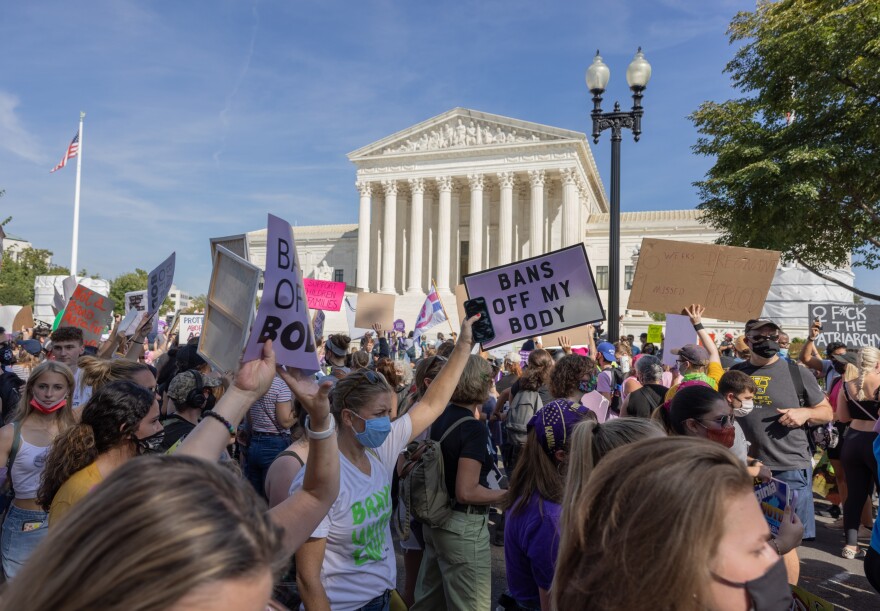 The US Supreme Court building with protesters outside