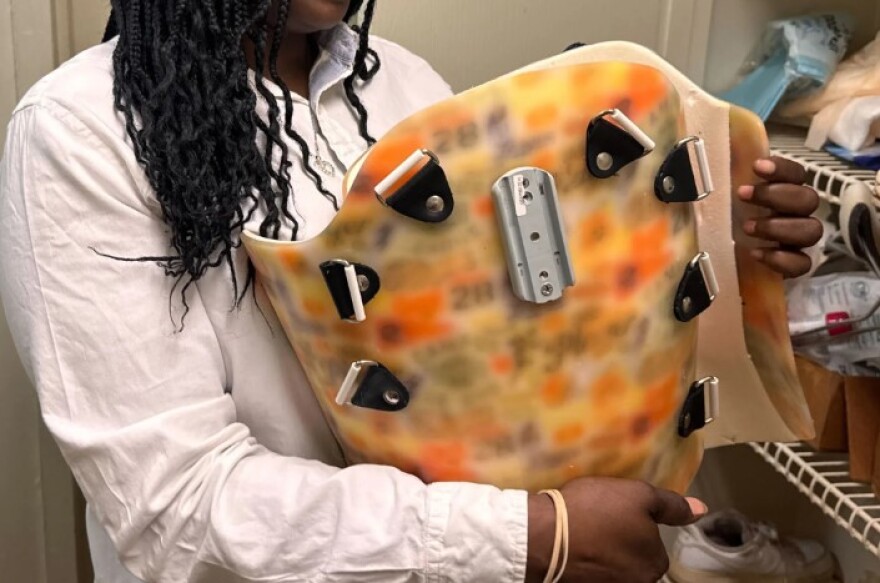 Quette with the brace that her teenage son needed after he was paralyzed in a shooting. She cared for him in her Illinois home, she says, until it became too difficult to keep him healthy there. KFF Health News agreed to use only her nickname to protect the safety of her son.