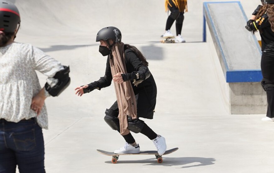 Rochester International Academy student Sadia works on rolling down a bank at the Roc City Skatepark.