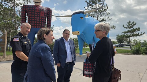 U.S. Sen. Amy Klobuchar, front left, visits with a staffer in front of Paul Bunyan and Babe the Blue Ox with Bemidji Fire Chief Justin Sherwood, back left, and Mayor Jorge Prince, center, on July 25, 2025.