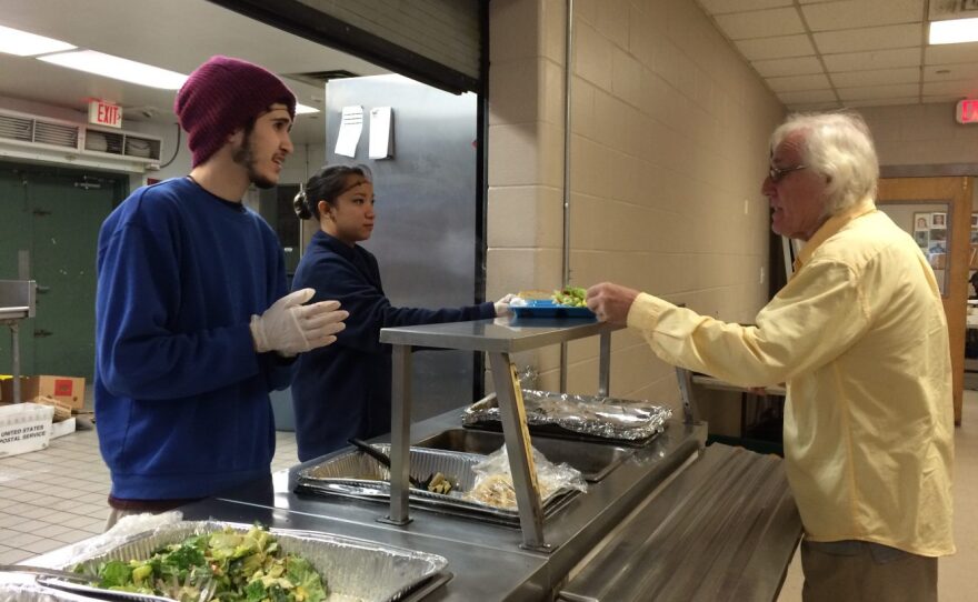 University of Florida students Joseph Peralta, 19, and Genelle Samson, 19, serve food to a St. Francis House visitor today as part of the national Martin Luther King Jr. Day of Service. (Melissa Smith/WUFT News)