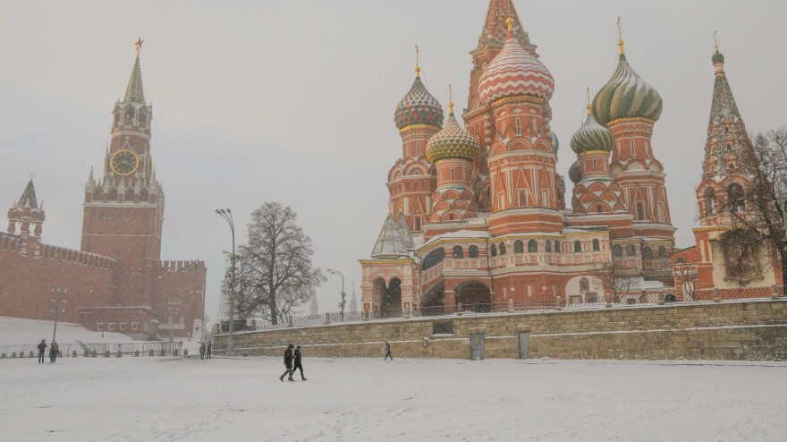 People walk under a heavy snowfall in front of St. Basil's Cathedral and the Kremlin in Moscow in January.