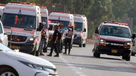 Israeli rescue teams wait next to ambulances parked just outside the southern city of Sderot to evacuate the wounded on Oct. 7, 2023, after the Palestinian militant group Hamas launched a large-scale surprise attack on Israel, firing a barrage of rockets from Gaza and sending ground units to kill or abduct Israelis. (Menahem Kahana/AFP via Getty Images)