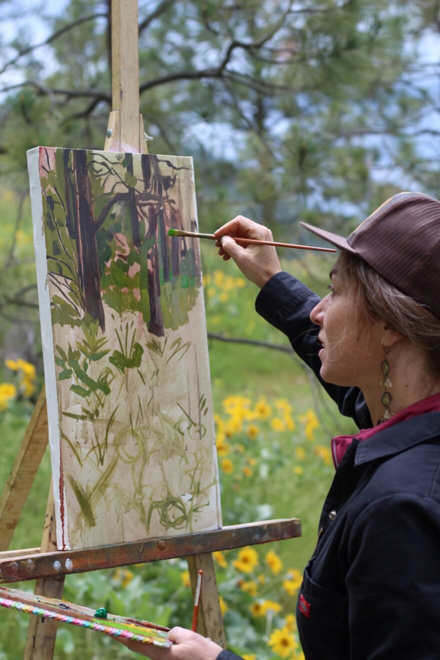 Artist Jorden Heidal paints on the South Hill Bluffs in Spokane during the 2022 Blush on the Bluff event. She will return for this year's event.