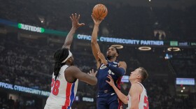 Cleveland Cavaliers' Donovan Mitchell, center, shoots between Detroit Pistons' Isaiah Stewart (28) and Duncan Robinson, right, in the first half of Game 4 of a second-round NBA basketball playoff series Monday, May 11, 2026, in Cleveland. 