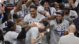 Dallas Mavericks guard Luka Doncic, center, celebrates with teammates after Game 5 of the Western Conference finals in the NBA basketball playoffs against the Minnesota Timberwolves, Thursday, May 30, 2024, in Minneapolis. The Mavericks won 124-103, taking the series 4-1 and moving on to the NBA Finals. (AP Photo/Matt Krohn)