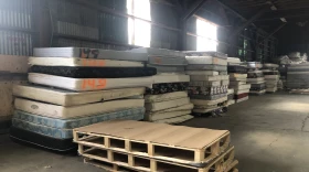 Used mattresses are stacked along a wall at the St. Vincent de Paul recycling facility in Eugene seen in April 2022. More mattresses may enter the recycling stream when the statewide mattress recycling program goes into effect in late 2024 or 2025.