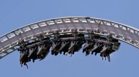 Visitors ride a roller coaster at Six Flags Magic Mountain in Valencia, Calif., April 1, 2021.