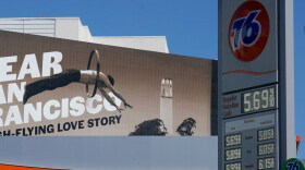 An advertisement for the show "Dear San Francisco: A High-Flying Love Story" is shown behind a price board at a gas station in San Francisco, Tuesday, March 8, 2022.