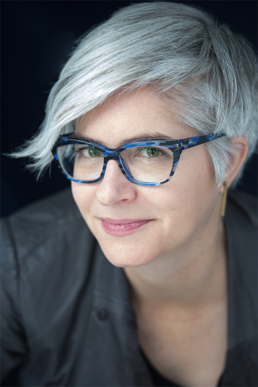 A head and one shoulder image of a woman with glasses. Megan Kate Nelson