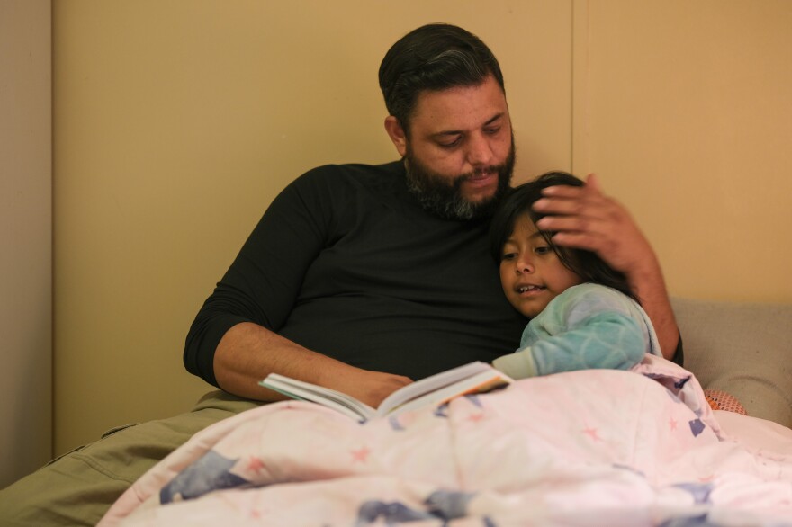 Jose Grajeda gives his daughter the same kind of soothing caress that he got from his mom when he was a child.