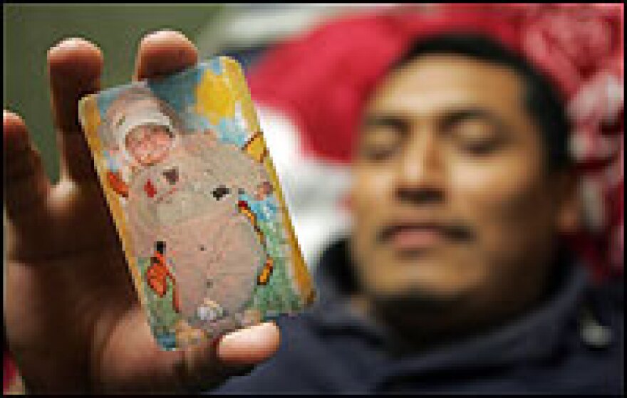 Undocumented Mexican laborer Juan Sanchez holds a photo of his baby son Gayel, born five months ago, who he has never seen. Sanchez and his cousins are among many undocumented workers helping to rebuild New Orleans.