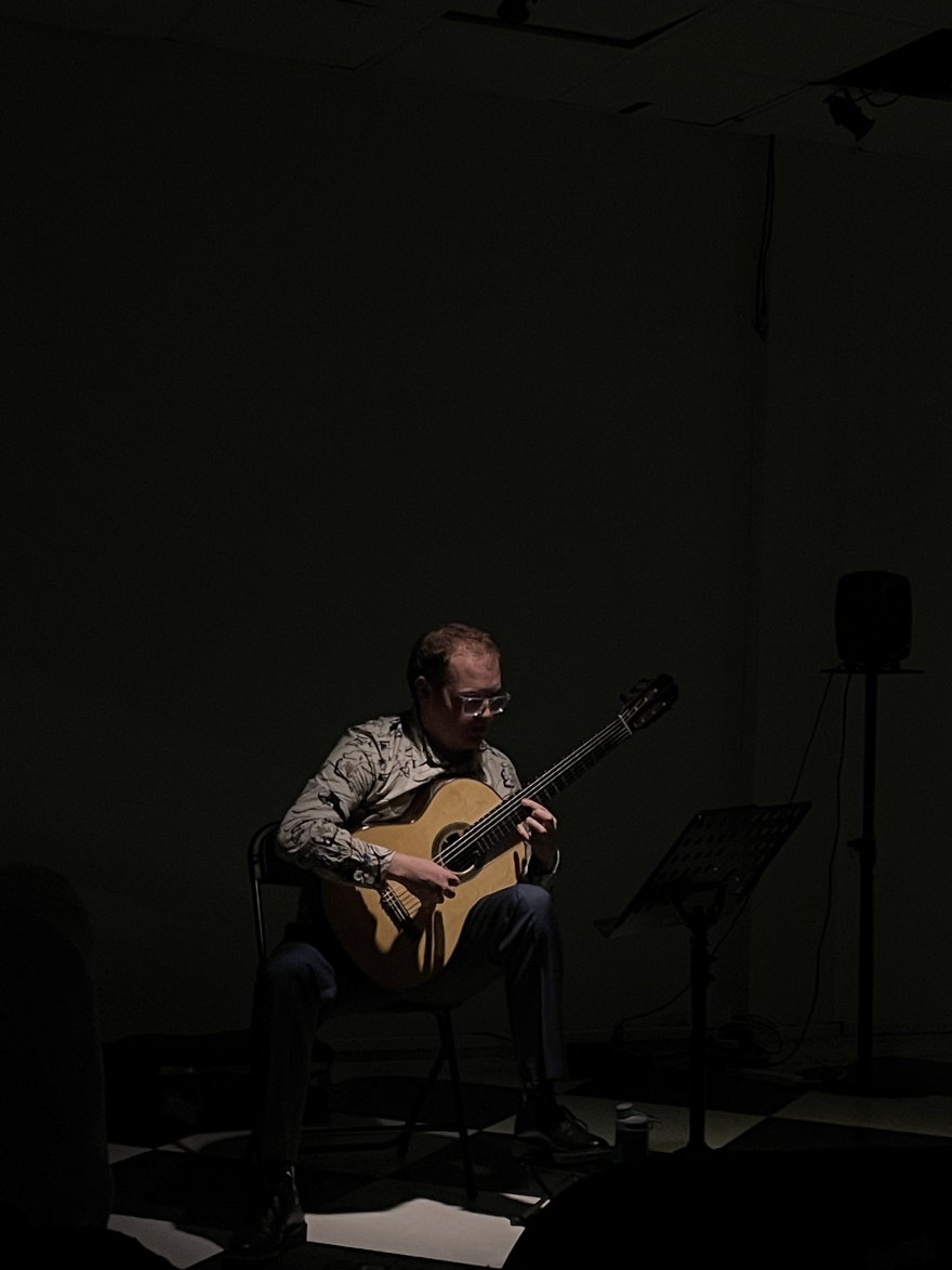 Guitarist Jamie Monck performing in a dark room