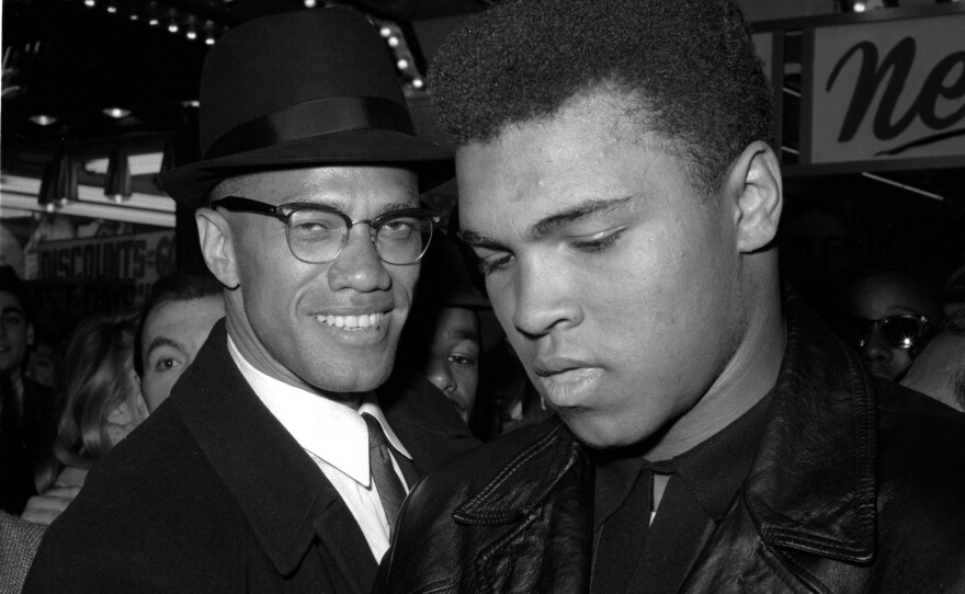 Muhammad Ali (right) is shown with Malcolm X, outside the Trans-Lux Newsreel Theater in New York City, after watching a screening of films on Ali's title fight with Sonny Liston on March 1, 1964.