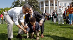 President Barack Obama helps a young participant roll an egg during the White House Easter Egg Roll on the South Lawn of the White House on April 9, 2012 in Washington, DC.