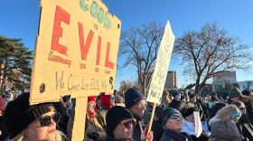 Attendees at the Renee Good vigil hold signs condemning ICE. 