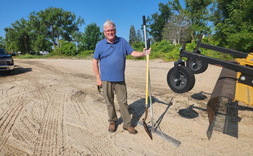 MIShores founder Jeff Welch stands with a shovel during a beach clean up near Blair Street Pier in Alpena on Friday, July 24, 2026.