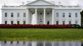 The White House is seen reflected in a puddle, Saturday, Sept. 3, 2022, in Washington.