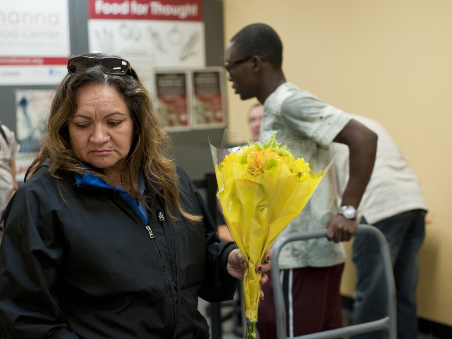 Judith Prado picks a bouquet of flowers to take with her other donations from the food pantry.