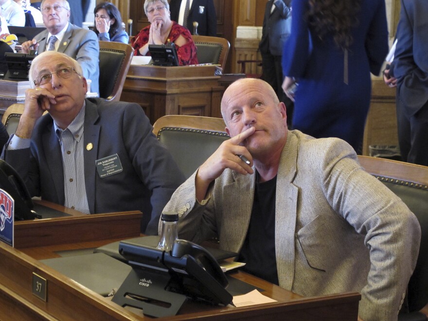 Kansas lawmakers watch an electronic voting board during votes on a bill to raise taxes and boost school funding at the Statehouse in Topeka, Kan.