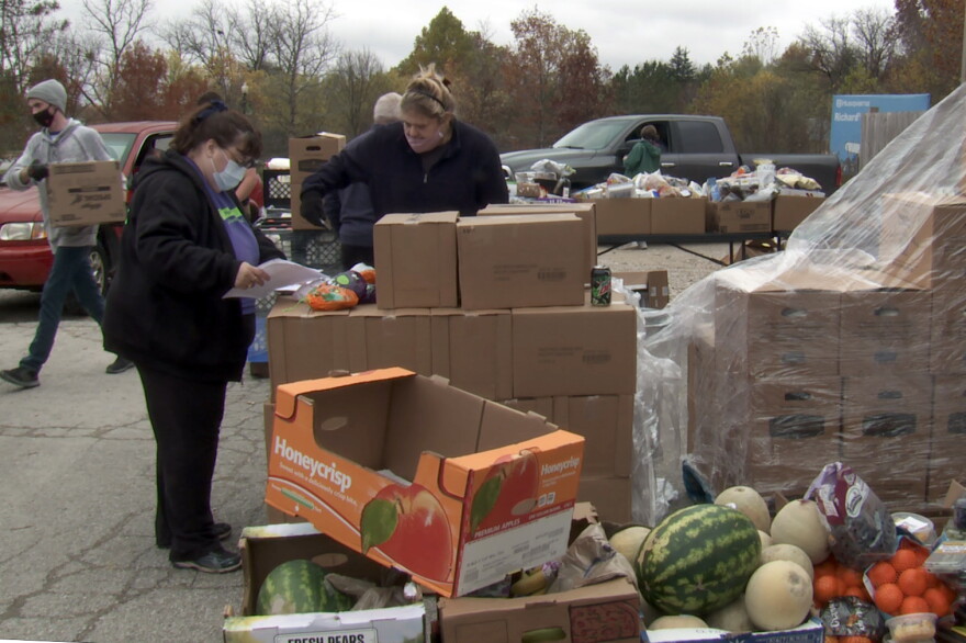 Pantry 279 director Cindy Chavez (masked, purple shirt) checks some last-minute details before food distribution begins.