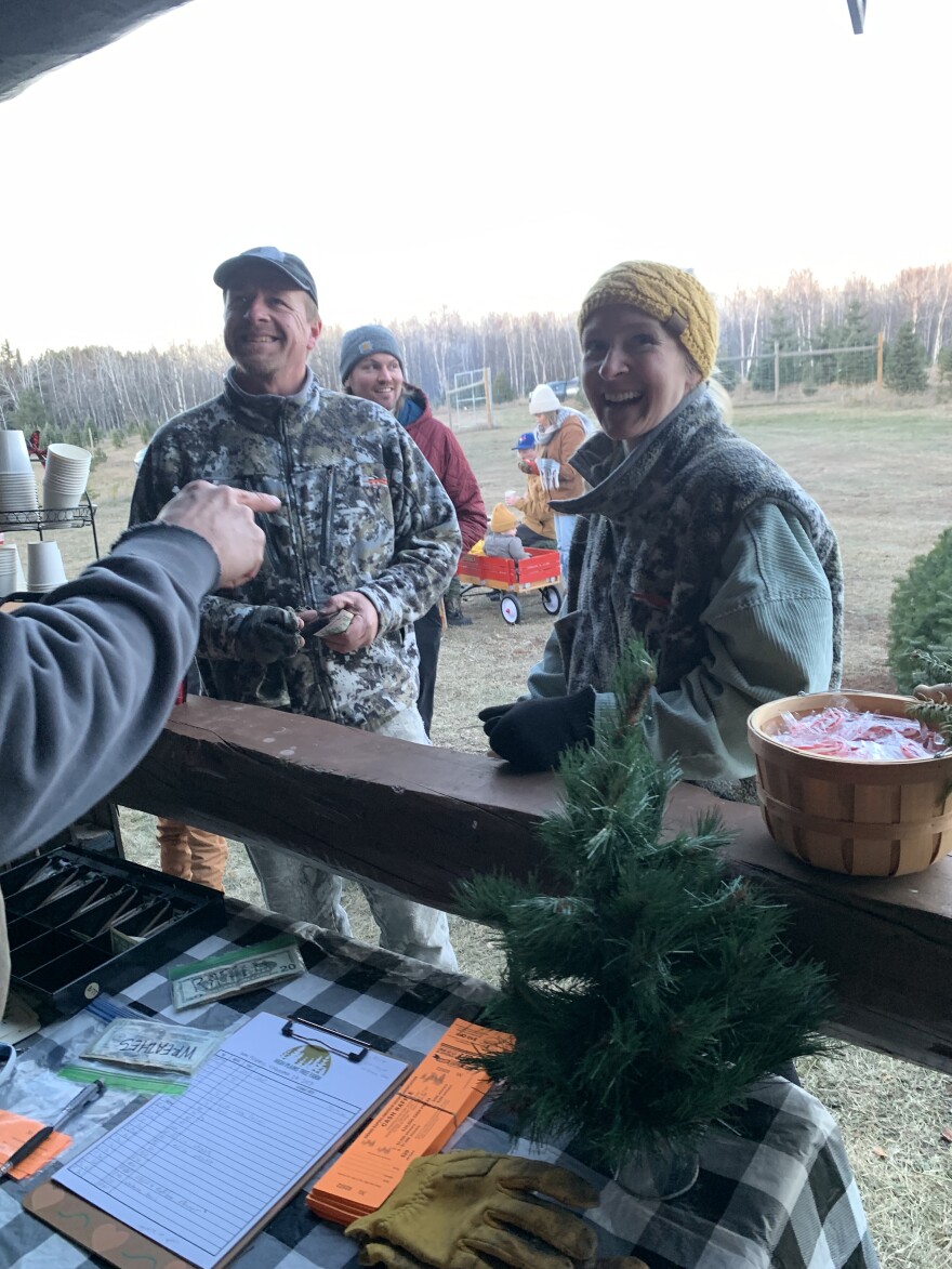 Customers laugh in conversation Friday, Nov. 24, 2023, at High Plains Tree Farm north of Grand Rapids.