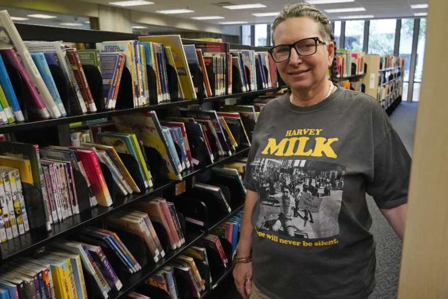 Gretchen Robinson, a lesbian high school teacher in Orange County, Fla., poses for a photo at the downtown library, Saturday, Aug. 13, 2022, in Orlando, Fla. Educators are cautiously making changes as they wait to see how the new law governing lessons on gender and sexual orientation will be interpreted and enforced. (AP Photo/John Raoux)