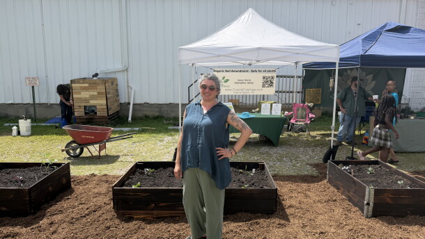 Beth Dryer, founder and executive director of the 757 Creative Reuse Center, stands in front of newly installed gardening beds during the "Back to Our Roots" community event along Colley Avenue.