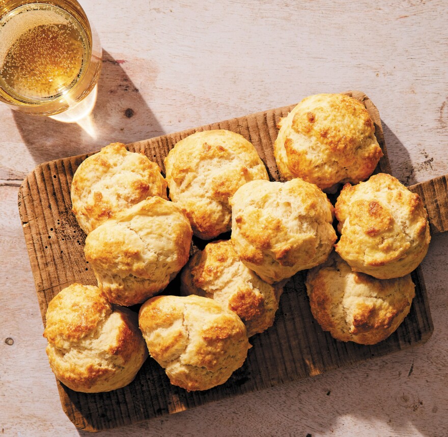 Freshly-baked biscuits laid out on a wooden cutting board.