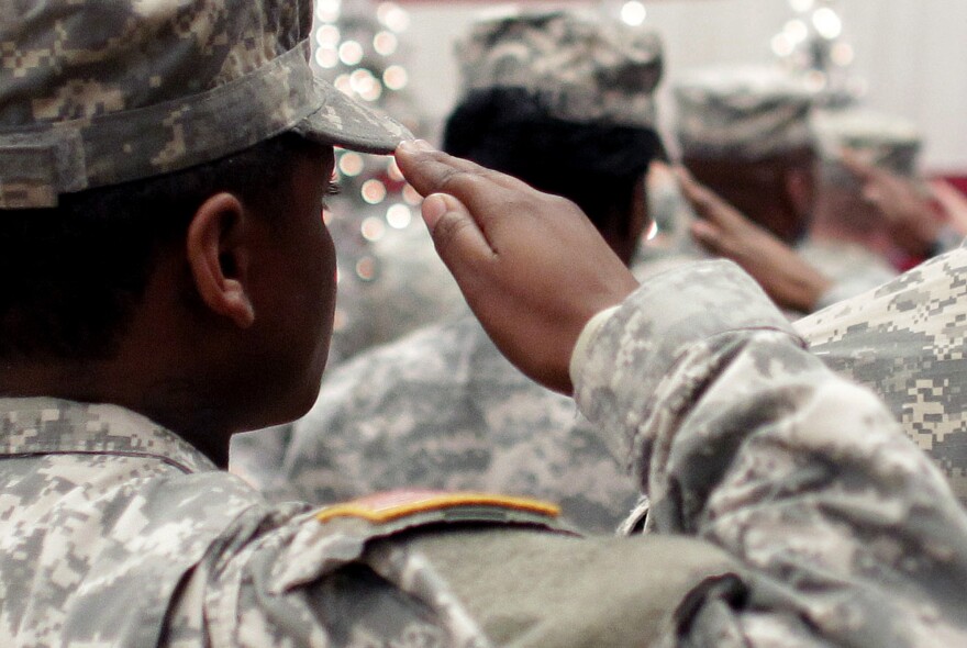 In this Wednesday Dec. 5, 2012, file photo, soldiers salute the U.S. flag during the Pledge of Allegiance at a welcome home ceremony for soldiers returning from a deployment in Afghanistan, at Fort. Carson, Colo. For veterans, the GI Bill can be the ticket to a debt-free college education.