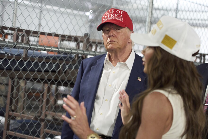 FILE: Close up of a man wearing a red hat as woman in white hat talks