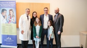 Dr. Brad Schlaggar and Dr. Ali Fatemi with a family (the McGinns) whose daughter, Ellie, has a rare disease that KKI treats and for which Dr. Fatemi’s team is researching a cure.