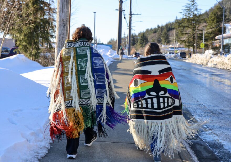 Chris Coulson and Sisi Haven Marr walk to Juneau-Douglas High School: Yadaa.at Kalé wearing the Weaving Our Pride robes.