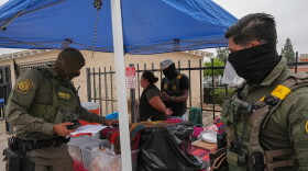 A woman is detained by U.S. Border Patrol agents outside a Home Depot in Los Angeles on Aug. 15, 2025.