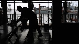 A Haitian worker with Temporary Protected Status cleans and busses tables at Half Shell Raw Bar, Friday, July 24, 2026, in Key West, Fla.