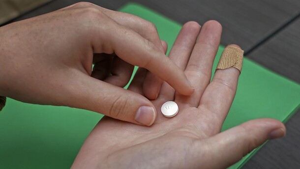 A patient prepares to take the first of two combination pills, mifepristone, for a medication abortion during a visit to a clinic in Kansas City, Kan., on, Oct. 12, 2022. 
