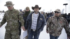 Ammon Bundy, center, one of the sons of Nevada rancher Cliven Bundy, walks off after speaking with reporters during a news conference at Malheur National Wildlife Refuge headquarters Monday, Jan. 4, 2016, near Burns, Ore.
