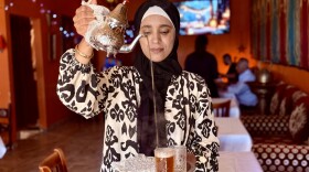 A staff member pours tea at Dar Tajine, a Moroccan restaurant in Planation, offering authentic Moroccan cuisine.