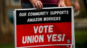 A person holds "Vote Union Yes!" signs during a protest in solidarity with Black Lives Matter, Stop Asian Hate and the unionization of Amazon.com, Inc. fulfillment center workers at Kelly Ingram Park on March 27, 2021 in Birmingham, Alabama. (Patrick T. FALLON/AFP via Getty Images)