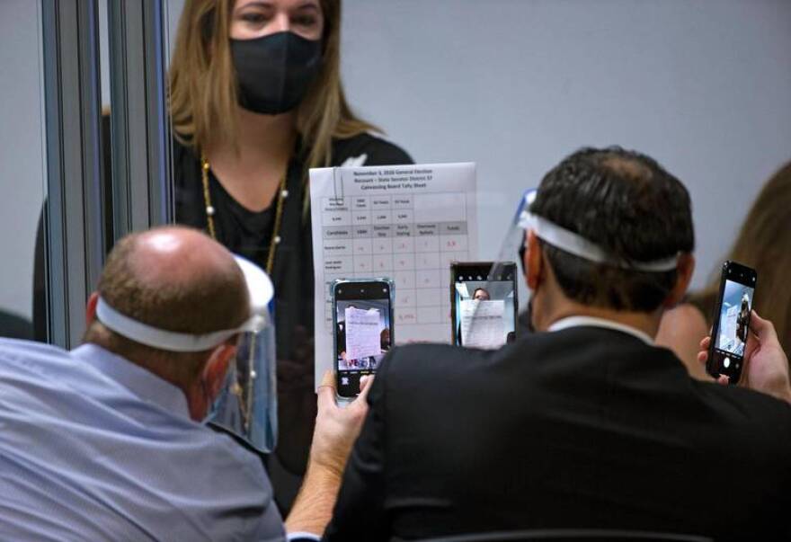 Chair of the Miami-Dade Democrats and layer Steve Simeonidis looks a ballot with a magnifier during manual recount for Senate District 37 between Republican Ileana Garcia and Democrat Jose Javier Rodriguez at Miami-Dade Elections Department on Thursday, November 12, 2020, in Miami, Florida.