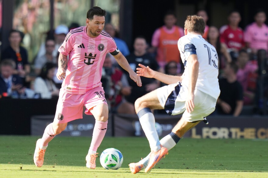Inter Miami forward Lionel Messi (10) runs with the ball as Vancouver Whitecaps forward Thomas Müller (13) defends during the first half of the MLS Cup final soccer match Saturday, Dec. 6, 2025, in Fort Lauderdale, Fla.
