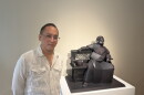 Artist Warren King stands next to his cardboard sculpture titled "The Emperor Takes Five."