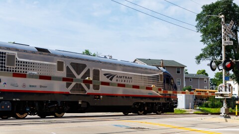 An image of an Amtrak Passenger rail engine at a crossing in Uptown Normal